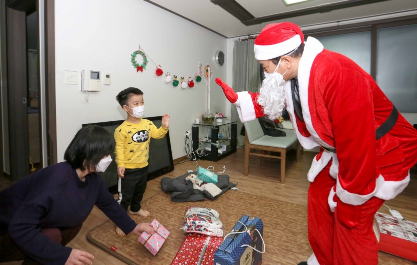 1. 산타클로스로 변신한 백군기 용인시장이 24일 크리스마스 이브를 맞아 최정민(10· 가명)군의 집에 깜짝 방문, 선물을 전달하기에 앞서 최군과 반갑게 인사하고 있다. (1).jpg