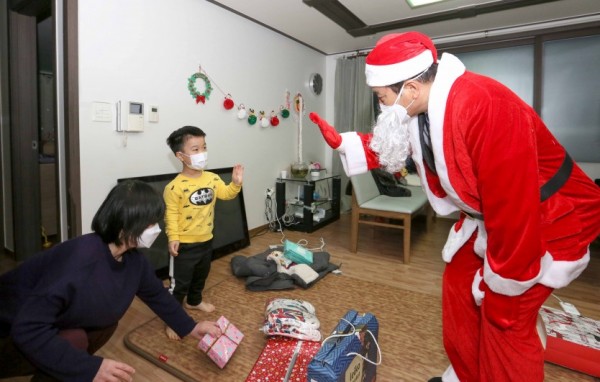 1. 산타클로스로 변신한 백군기 용인시장이 24일 크리스마스 이브를 맞아 최정민(10· 가명)군의 집에 깜짝 방문, 선물을 전달하기에 앞서 최군과 반갑게 인사하고 있다. (1).jpg